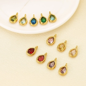Detail of 11 faceted teardrop pendants with gold plated borders and colorful gems