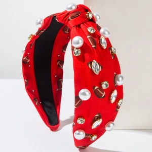 Détail d'un serre-tête rouge noué avec imprimés football, grosses perles et strass