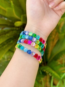 Primer plano de pulseras elásticas de cristal de colores con forma de corazón