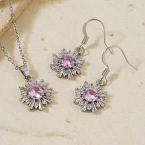 Close-up of snowflake jewelry set with pink stones and silver finish on stone