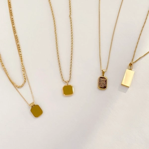 Flat lay of vintage gold-plated layered necklaces with black onyx and square pendants