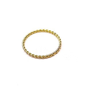 Macro shot of minimalist golden twisted rope ring with elegant metallic texture