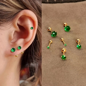 Macro detail of green zircon stud earrings with gold screw backs and model ear styling