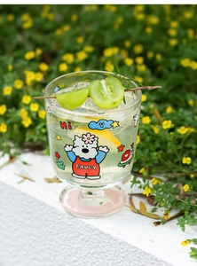 Gros plan d'un verre à pied mignon avec motif de dessin animé sur fond de jardin