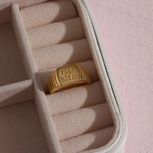 Vergoldeter Rich Bitch Statement-Ring präsentiert in einer luxuriösen beigen Samtbox
