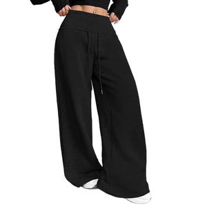 Detail of high-waist wide-leg pants with elastic drawstring waist in black fabric