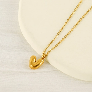 Close-up of a 18K gold-plated bubble letter V pendant on a minimalist metal chain