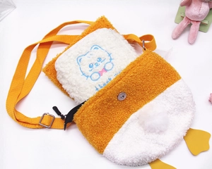 Detail of plush yellow duck crossbody bag showing removable cat pouch and magnetic snap