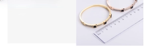 Close-up of vacuum plated gold bracelets with black square stones and inlaid rhinestones