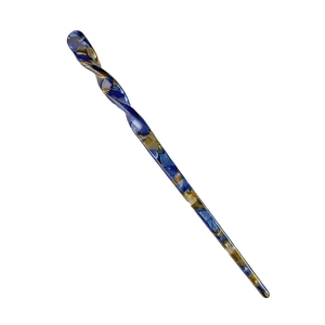 Nahaufnahme eines Haarstabs aus blau-gelbem Acetat mit gedrehtem Spiral-Design