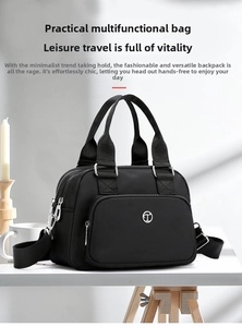 Detail view of black nylon shoulder bag with metal logo and adjustable wide strap