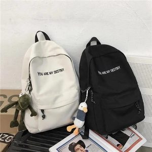 Sac à dos en toile minimaliste noir et blanc avec lettrage et pendentifs peluche