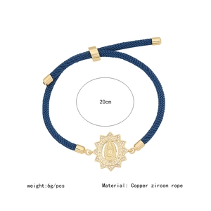 Detail view of adjustable blue woven rope bracelet with gold Virgin Mary zircon charm
