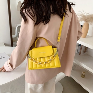 Fashionable bright yellow quilted crossbody bag with chunky chain decor and top handle