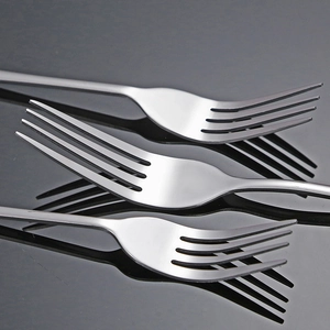 Three premium thick stainless steel forks set on a black reflective surface for dining