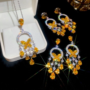 Detail of silver jewelry set with yellow teardrop and butterfly gems and tassels