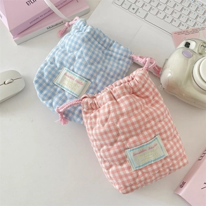 Detail of heart-quilted cotton camera pouches in blue and pink checkered patterns