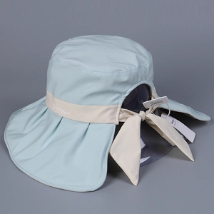 Detail of light blue sun hat with wide brim, neck flap and beige decorative bow strap