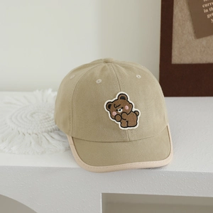 Close-up of cute brown bear embroidery patch and hemmed brim on kids cotton baseball cap