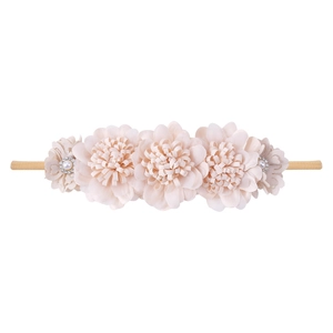 Detail of pink fabric flowers with pearls and crystals on an elastic baby headband