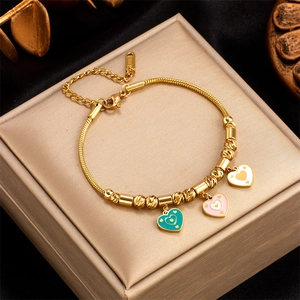 Detailed close-up of gold plated snake chain bracelet with green, pink, and white enamel hearts