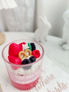 Close-up of strawberry chocolate dessert candle with berry toppings in glass cup