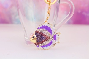 Detailed close-up of a purple rhinestone tropical fish keychain with gold-tone metal and enamel