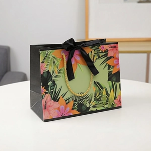 Floral gift bag with tropical hibiscus pattern, black satin bow and gold rope handles