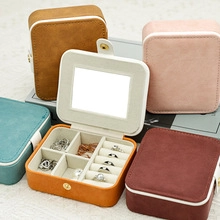 Close-up of portable leather jewelry boxes with vanity mirrors and multi-grid storage slots