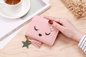 Pink PU leather coin purse detail with cartoon lashes, rhinestone bow, and tassel charm