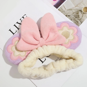 Macro view showing soft plush microfiber texture and floral embroidery on the headband