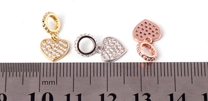 Micro-paved heart charms in gold, silver, and rose gold shown with a millimeter ruler
