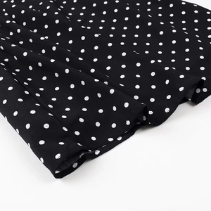Macro shot of polka dot fabric texture with fine edge stitching for a summer dress