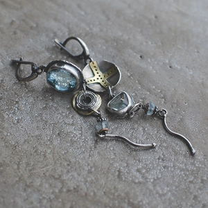 Detailed macro shot of vintage tribal long earrings with blue stones and silver cross metal