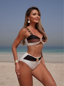 Three-tone color block bikini with gold scallop accessories on beach background
