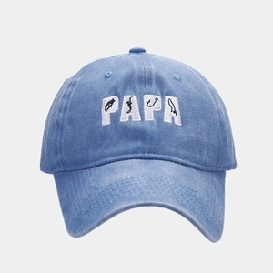 Close-up of white PAPA embroidery on vintage blue washed denim baseball cap texture