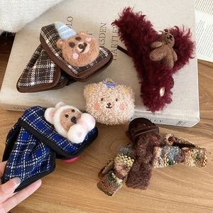 Detail of plush acrylic claw clips featuring teddy bears and autumn winter bow designs