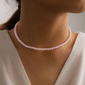 Close-up of pink round pearl choker necklace worn on neck for a soft and elegant look