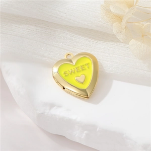 Detailed close-up of a heart locket with yellow enamel finish and sweet engraving