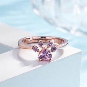 Detailed macro view of a rose gold open ring featuring a pink zircon cat paw design