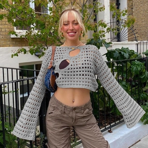 Detalle del tejido de un crop top gris de ganchillo con cortes calados y mangas acampanadas