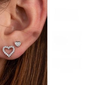 Detail of silver heart ear studs set with hollow and solid sparkling designs for women