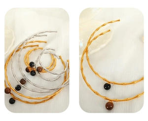 Macro detail of gold bamboo joint choker necklace with natural tiger eye stone pendant