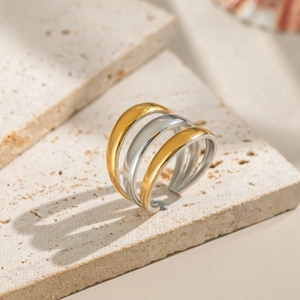 Minimalist layered ring with mixed gold and silver tones on a natural stone base