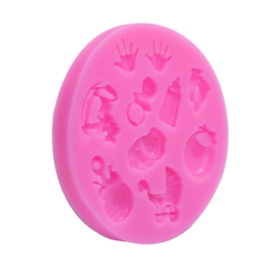 Pink silicone baby mold featuring handprints, bottles, and rocking horse shapes