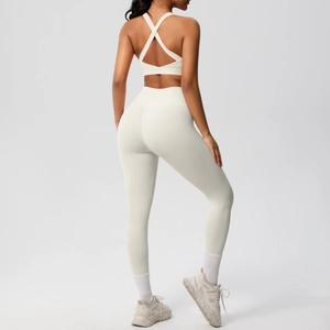 Vista posterior de sujetador deportivo cruzado y leggings de yoga de cintura alta en blanco