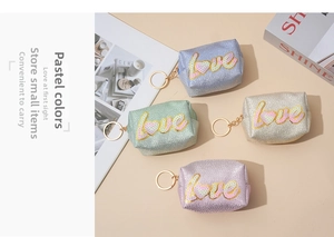 Macro detail of glitter coin purses with plush love letters and metal keychains