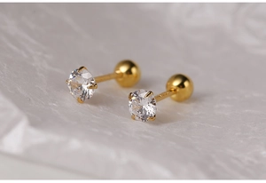 Macro shot of gold silver earrings featuring clear zircon stones and secure screw-back design