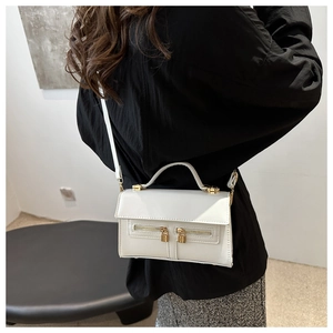 Détail du sac à bandoulière en cuir PU blanc avec doubles fermetures éclair dorées et anse