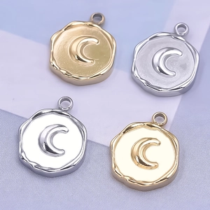 Macro shot of silver and gold crescent moon pendants in irregular round metal design